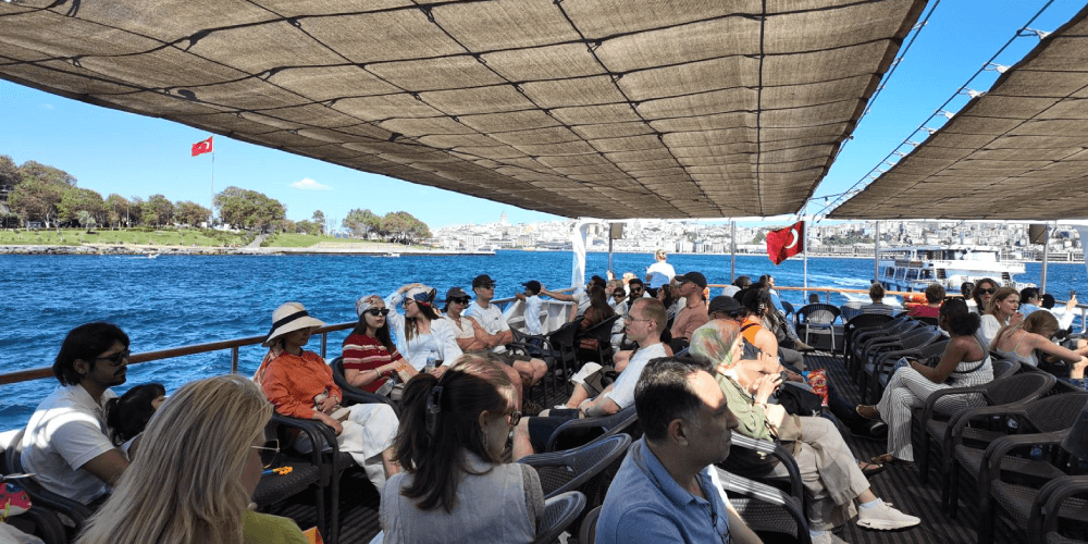 Morning Bosphorus boat tour in Istanbul passing historic waterfront mansions under clear skies